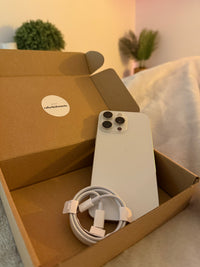 Refurbished iPhone 15 Pro Max in a box with charging cable from Marco's Refurbishments